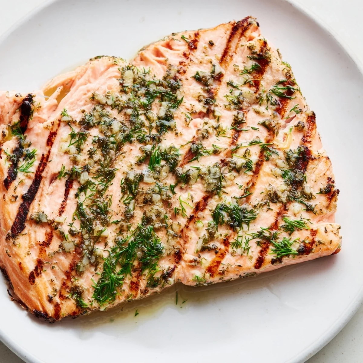 Sizzling Lemon Herb Grilled Salmon on a plate with asparagus and roasted potatoes.