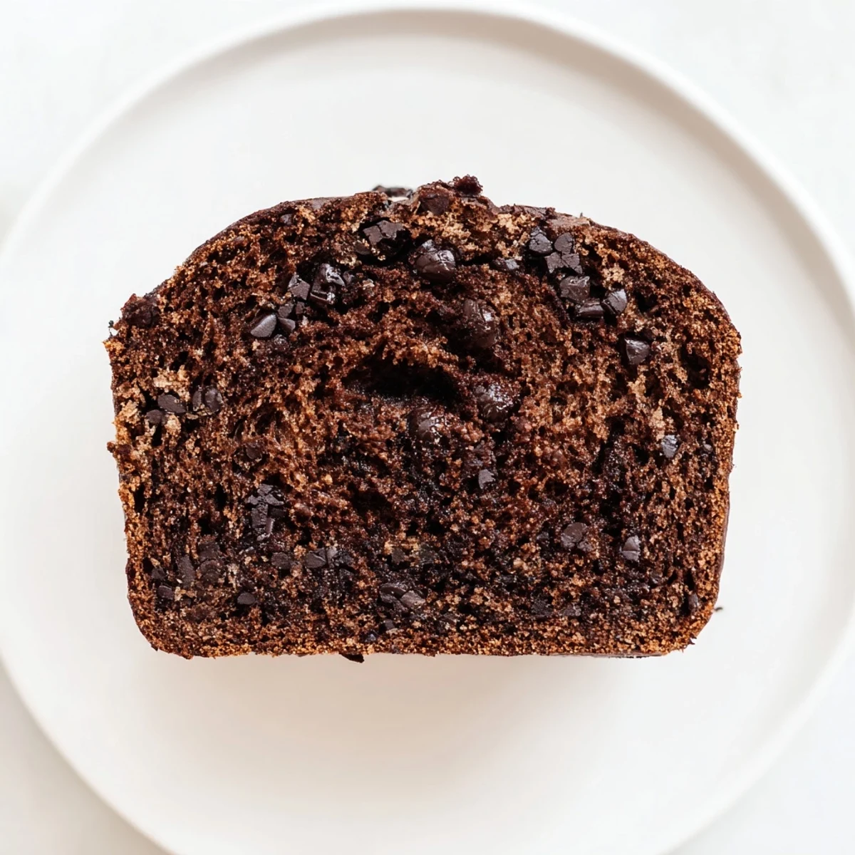 Warm, moist Chocolate Banana Bread slice studded with dark chocolate chips, perfect for breakfast or snacking.