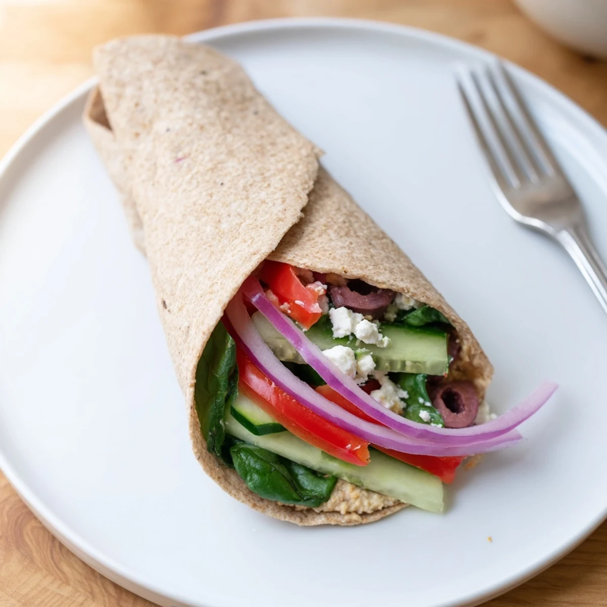 Fresh Mediterranean Sandwich Wrap ingredients like juicy tomatoes, red bell peppers, and kalamata olives ready for a quick vegetarian lunch.