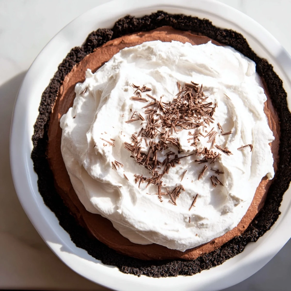 Velvety slices of Romantic Chocolate Silk Pie served chilled on a white plate, garnished with rich chocolate shavings.