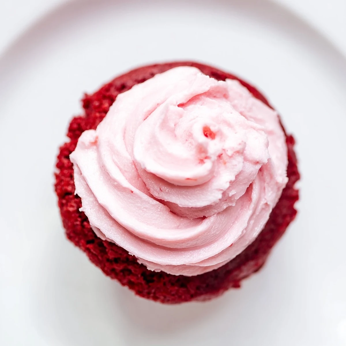 Moist, tender red velvet cupcakes with fluffy pink cream cheese frosting, ideal for celebrations or sweet indulgence at home.