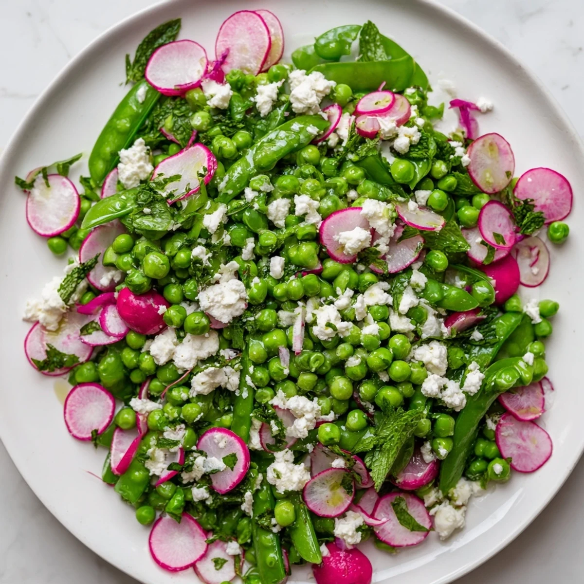 Serve this Spring Pea Salad with Radishes and Feta alongside grilled chicken for a refreshing summer lunch.