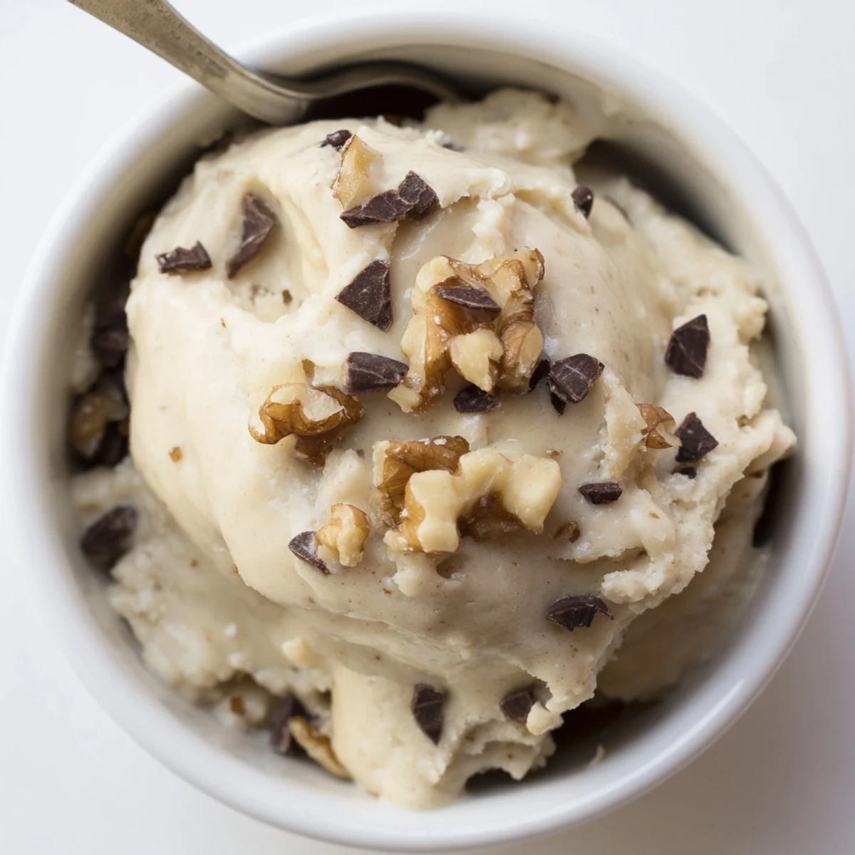 A close-up of Guilt Free Greek Yogurt Cookie Dough with dark and white chocolate chips, showing a creamy texture in a bowl.
