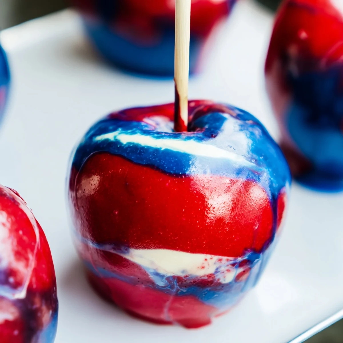Eight shiny apples are dipped in a swirled candy shell for the Marbled Effect Candy Apples recipe, displayed on parchment.