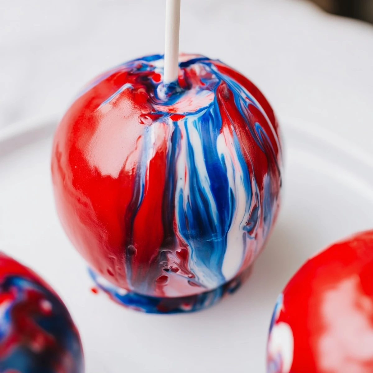 Serving suggestion for Marbled Effect Candy Apples: glossy candy apples on a tray with a light, sugary glaze.