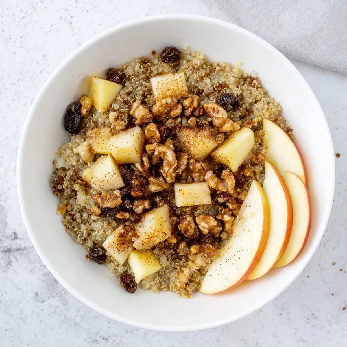 Healthy Quinoa Apple Breakfast served warm with cinnamon apples and creamy milk in a cozy bowl.