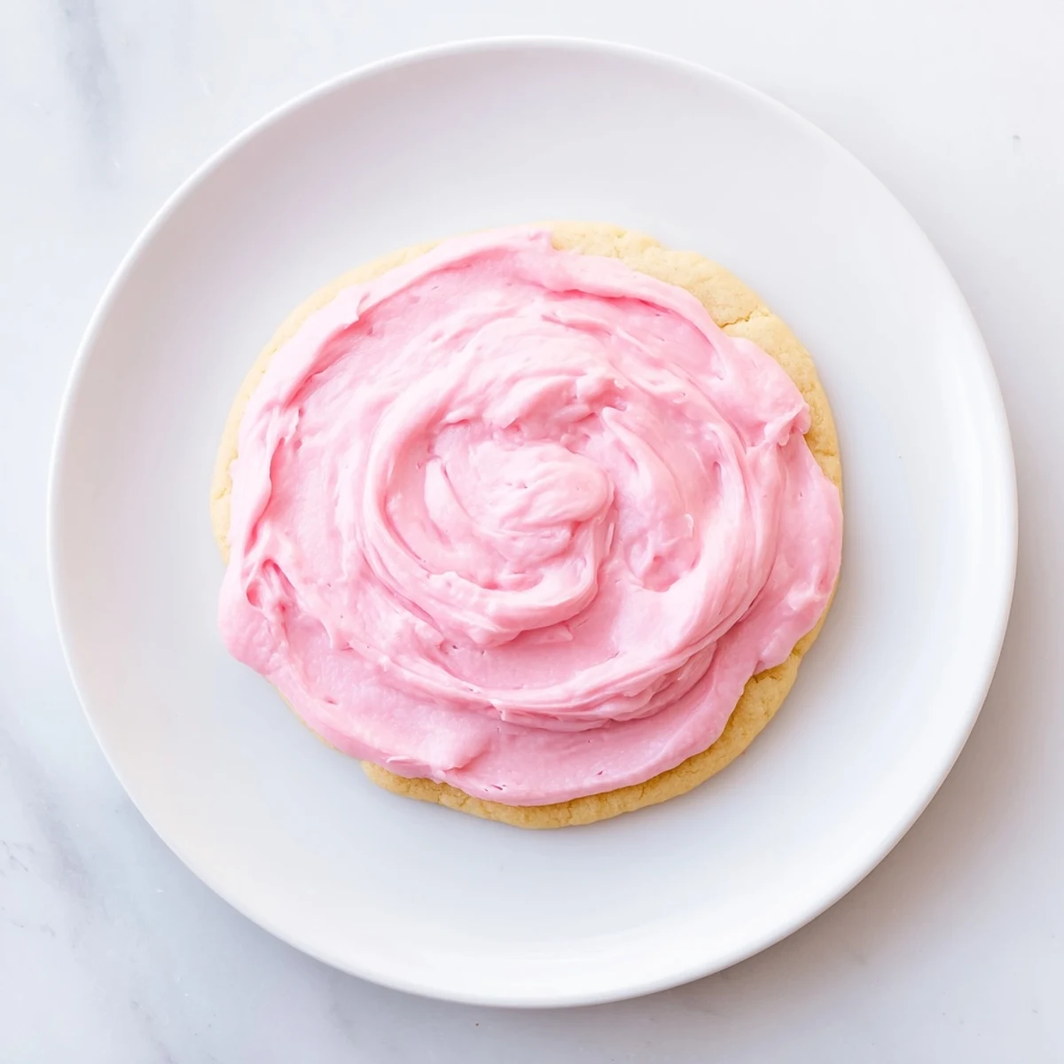 A close-up of Crumbl Pink Sugar Cookies with pink almond frosting, showing soft texture and bakery-style finish.