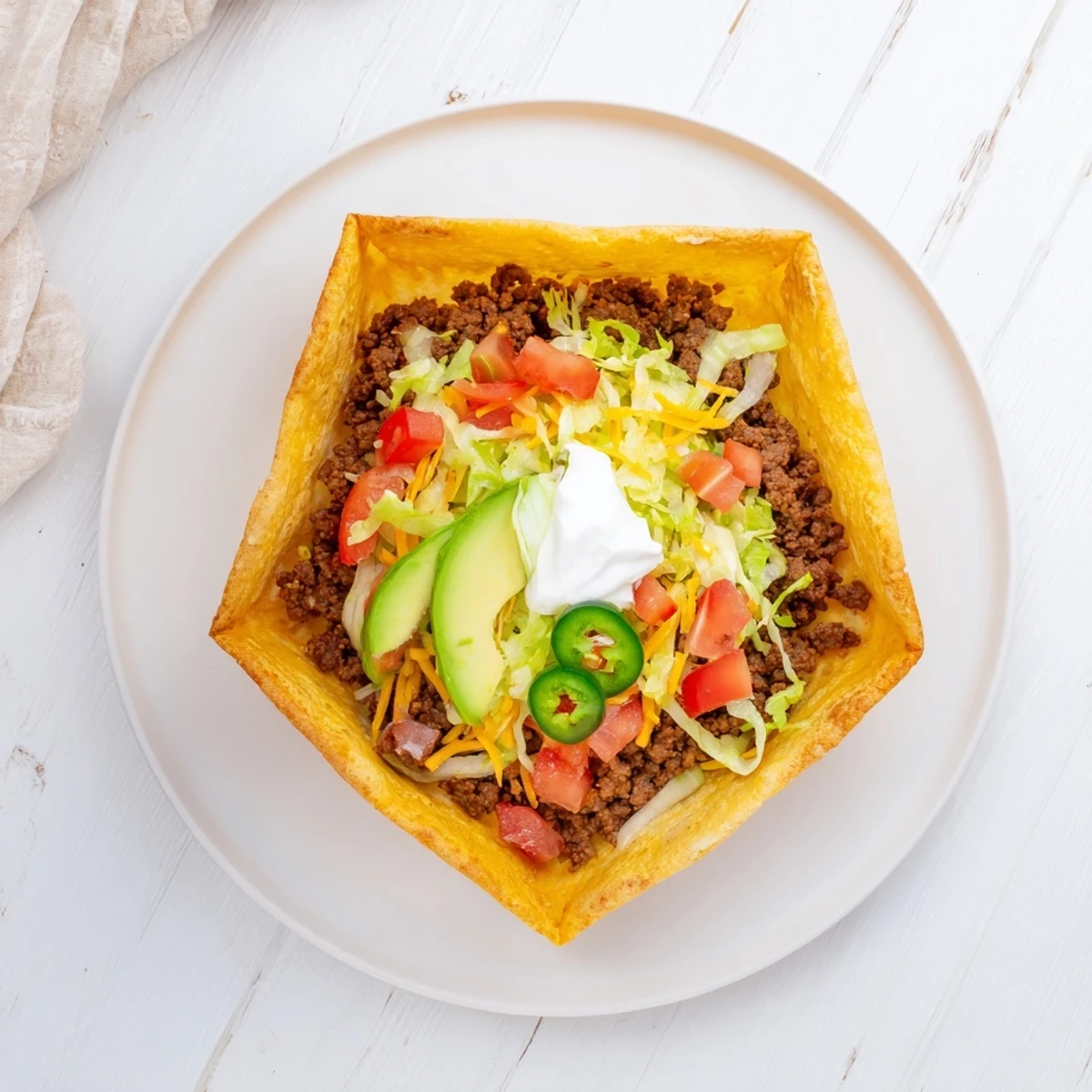 Crispy skillet-cooked keto crunchwraps sliced open revealing layers of seasoned meat, fresh lettuce, tomatoes, avocado, and creamy sour cream
