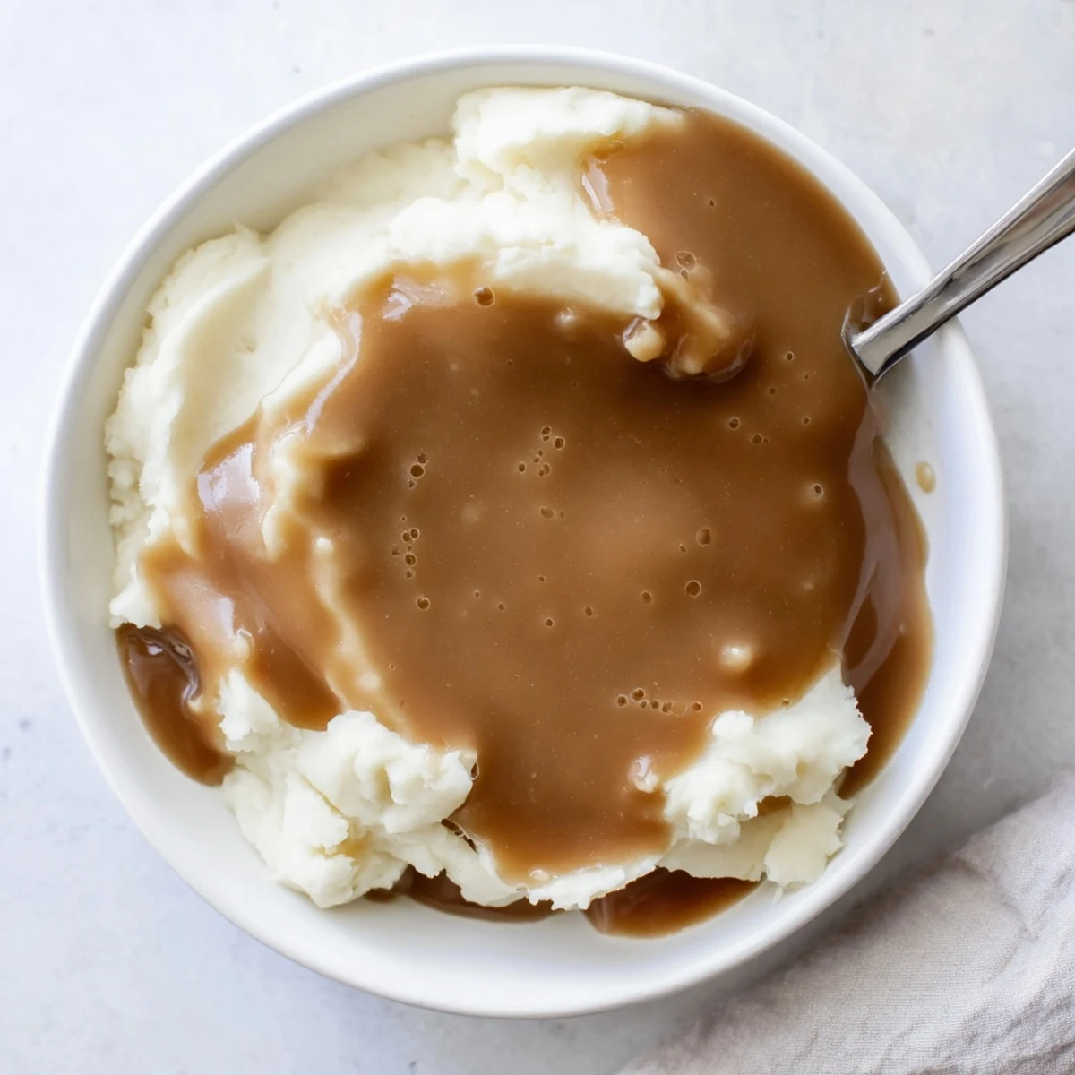Rich brown homemade gravy ladled generously over sliced roast beef with fresh parsley garnish