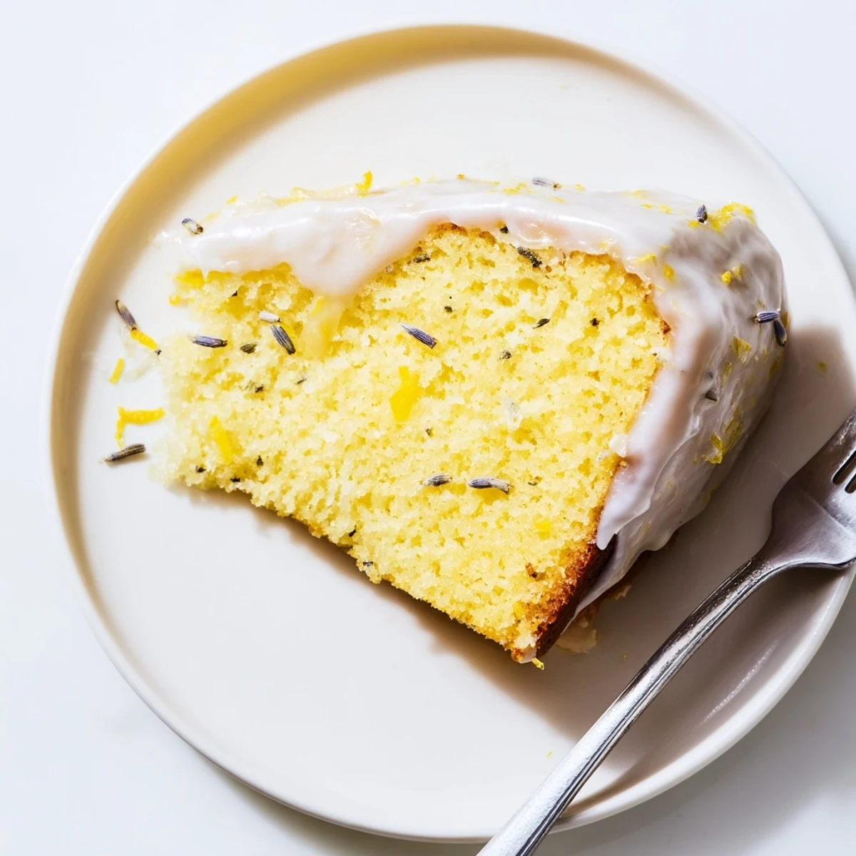 Elegant lemon lavender cake served on a rustic wooden board with zesty citrus glaze and floral accents