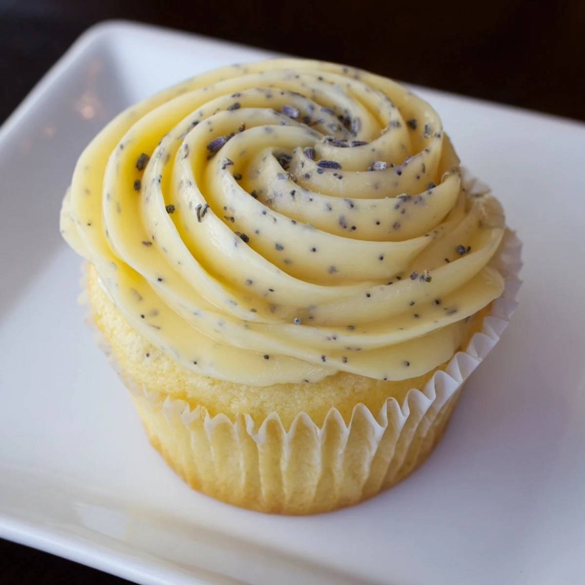 Golden lemon lavender cupcakes with zesty citrus flavor and subtle floral notes on a white serving plate.