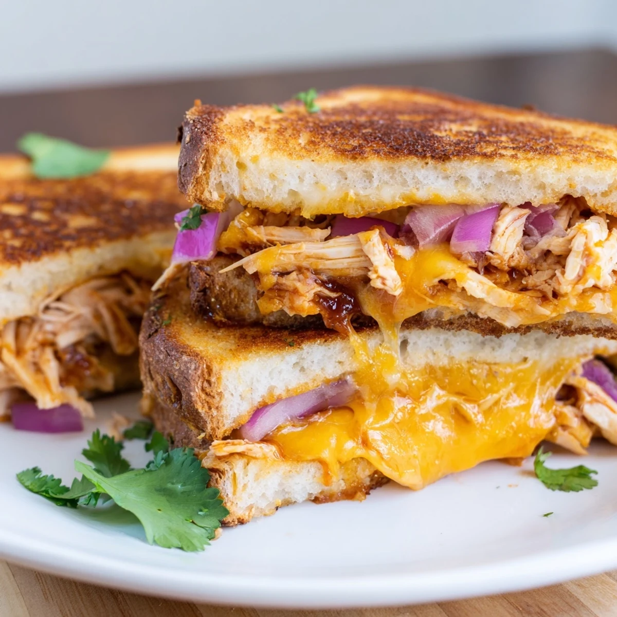 Savory BBQ chicken melts between golden toasted bread slices with rich, bubbling cheese layers