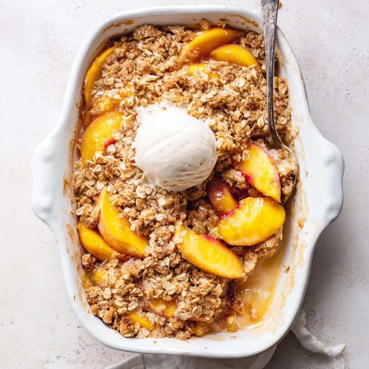 Bubbling fruit filling topped with buttery oat crumble on this warm baked cinnamon spiced peach crumble