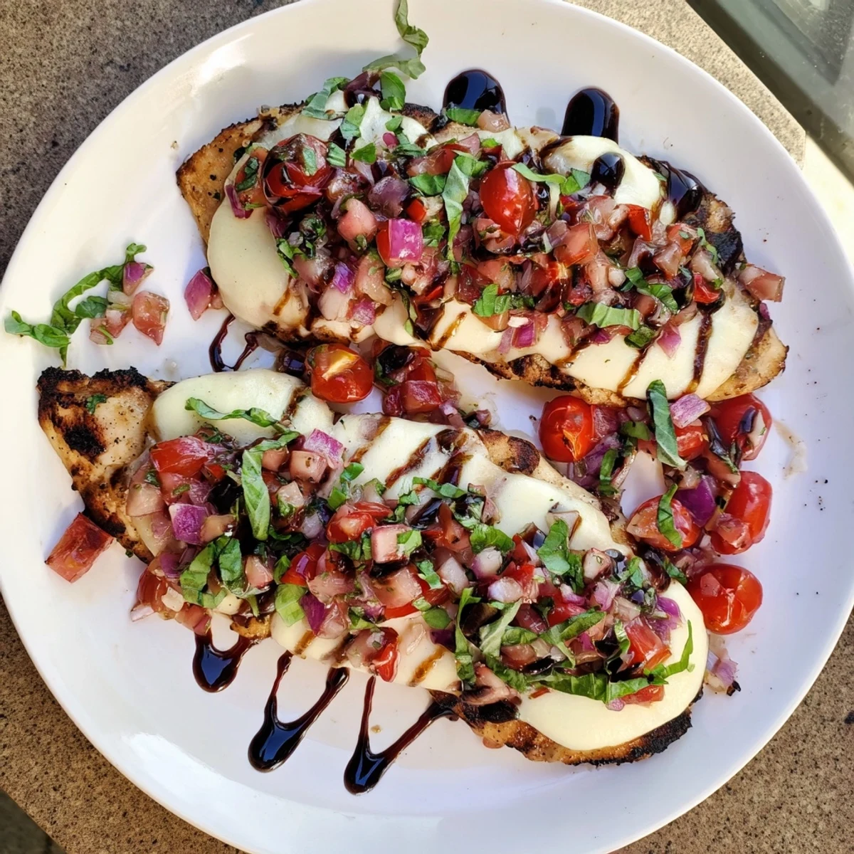 Savory Mozzarella Bruschetta Chicken served with basil garnish and balsamic glaze drizzle