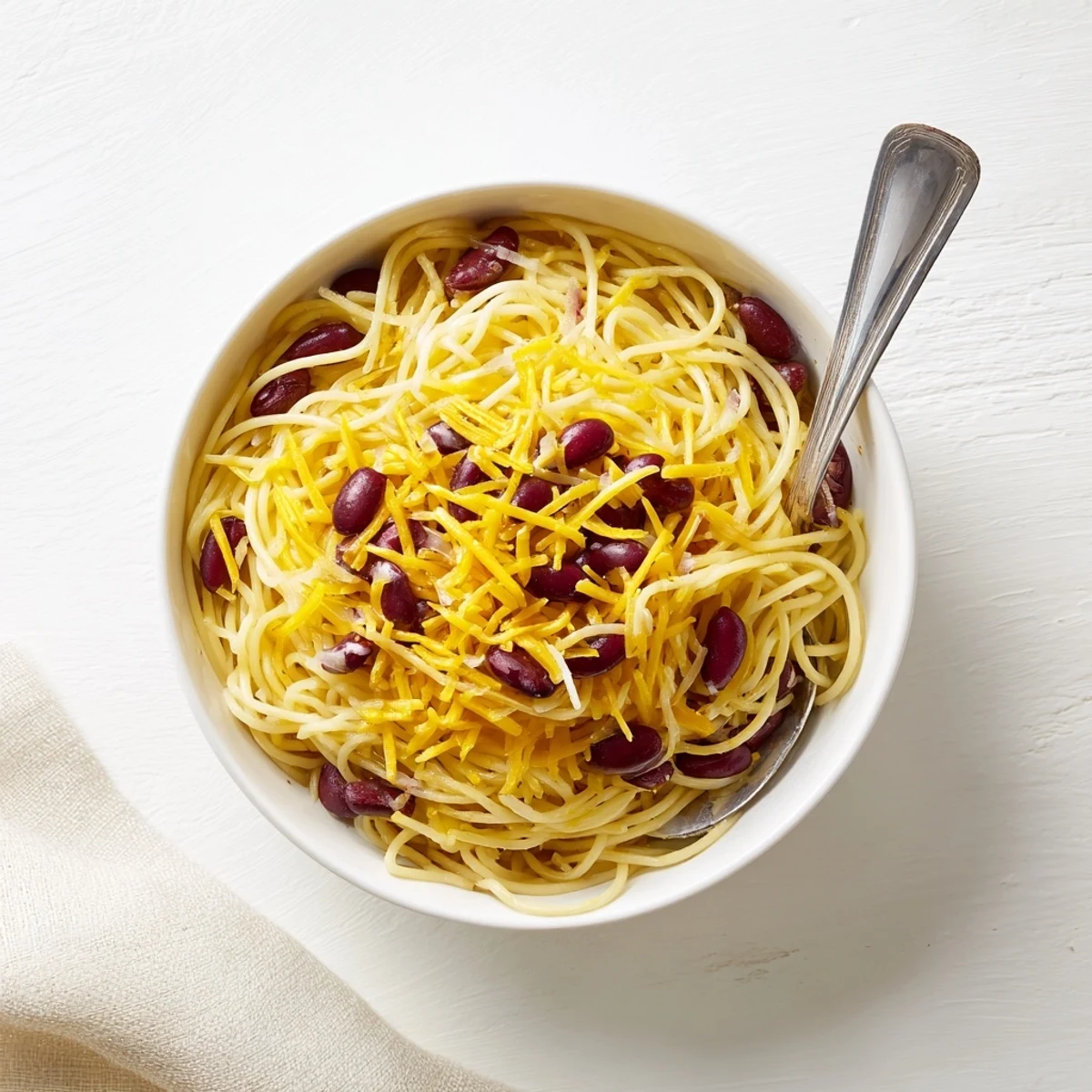 Traditional Cincinnati Chili served three-way style over spaghetti noodles with generous cheddar cheese topping