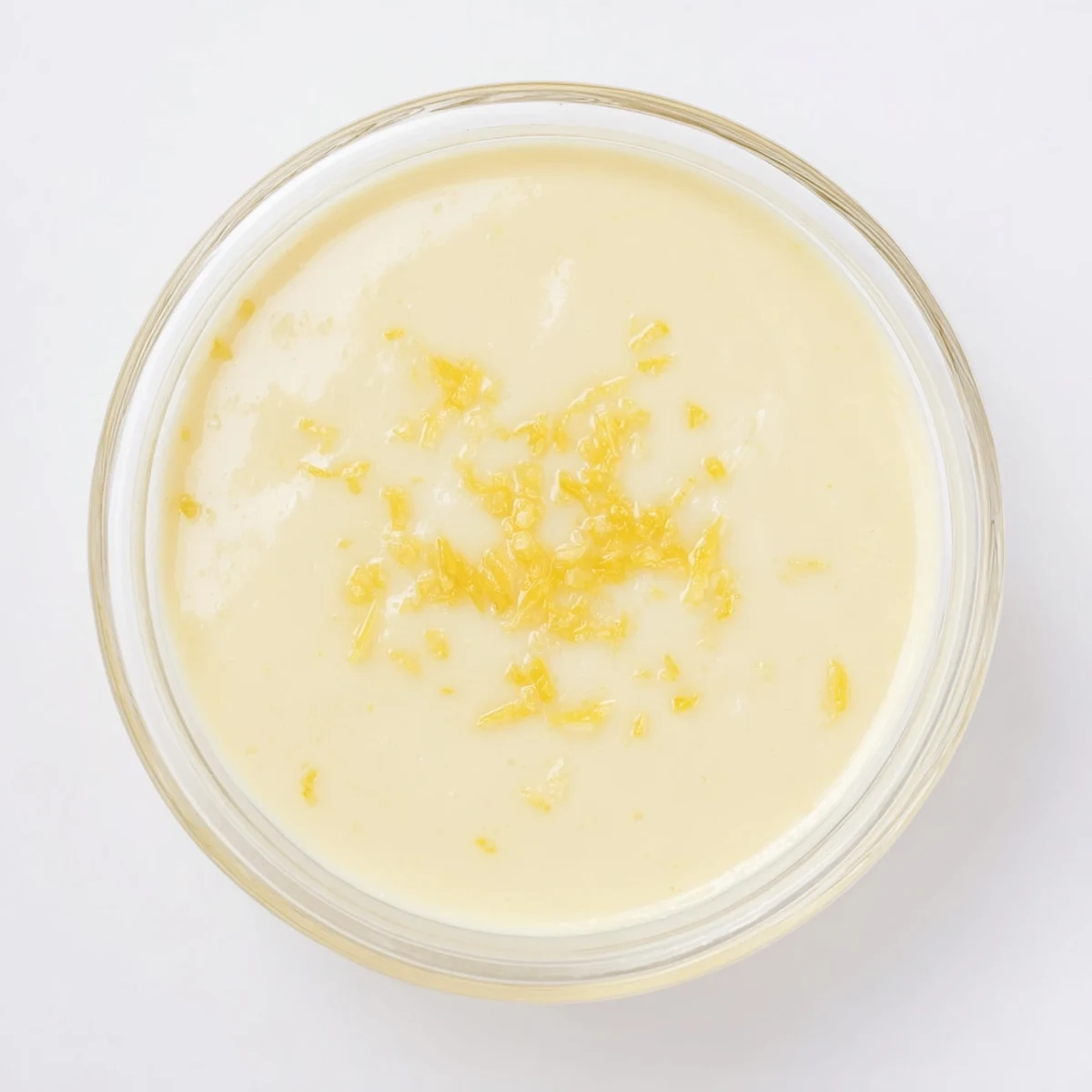 Creamy lemon posset dessert plated with fresh berries and crisp shortbread cookie