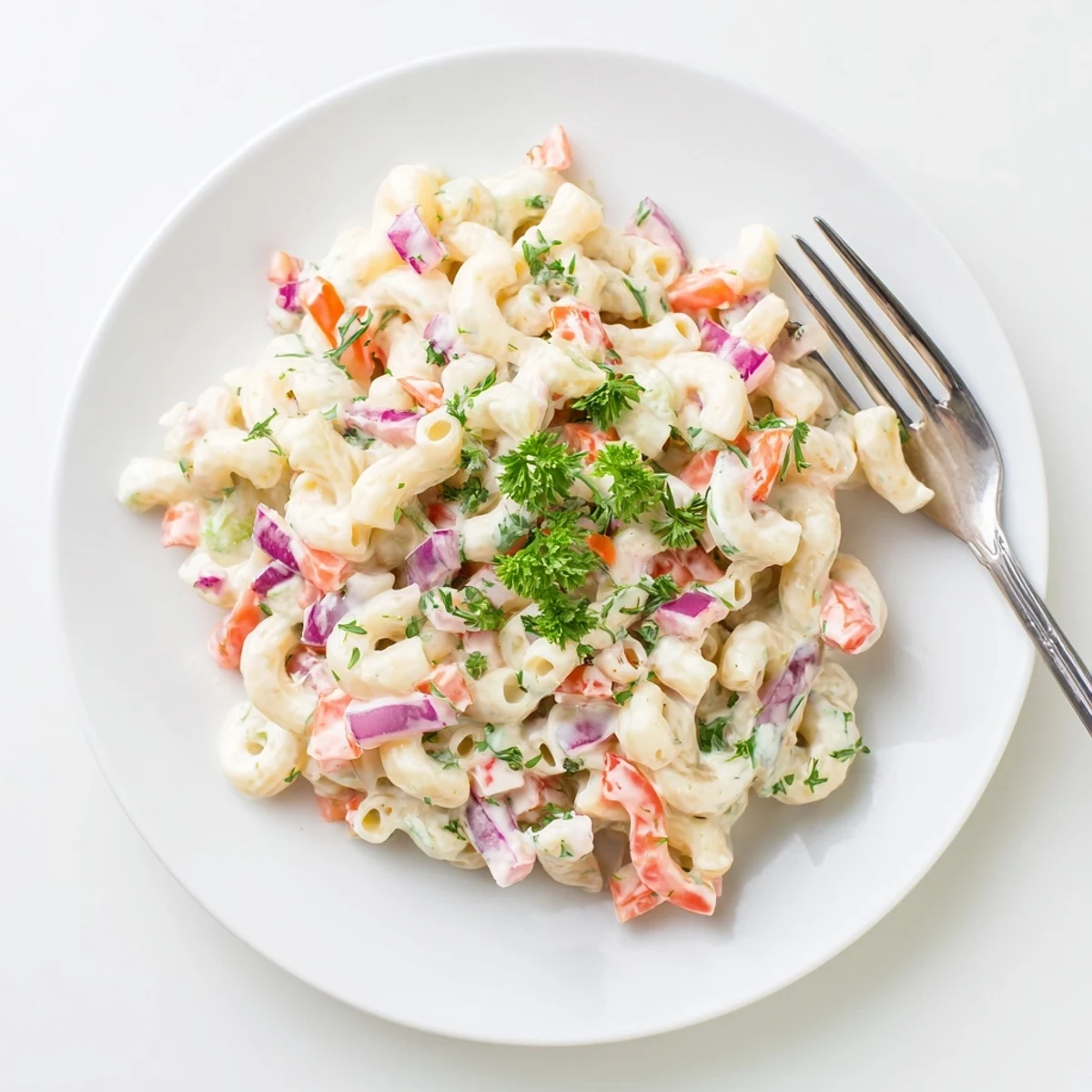 Creamy tangy macaroni salad bowl loaded with colorful diced vegetables and fresh parsley garnish