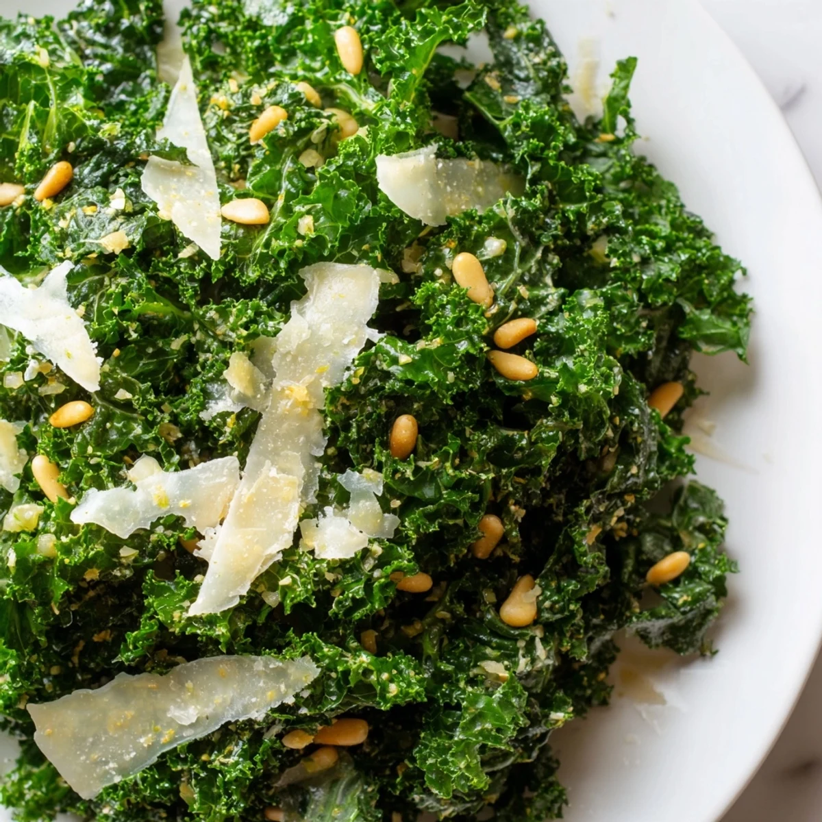 Crisp kale leaves coated in zesty garlic lemon Parmesan dressing ready to serve