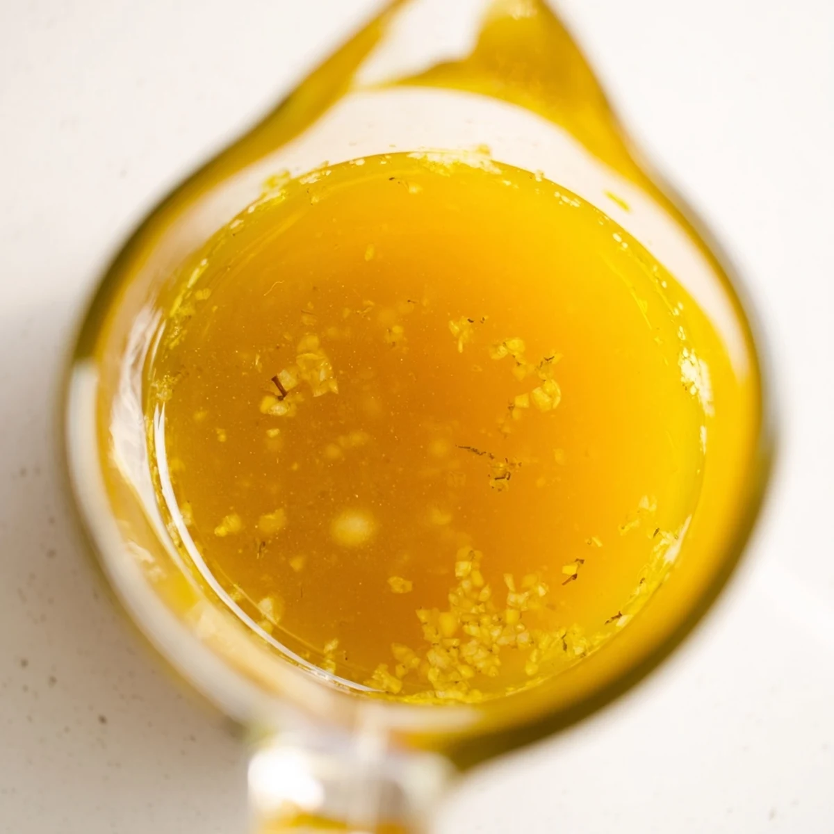 Golden citrus vinaigrette emulsified in a glass jar ready for drizzling over fresh salads