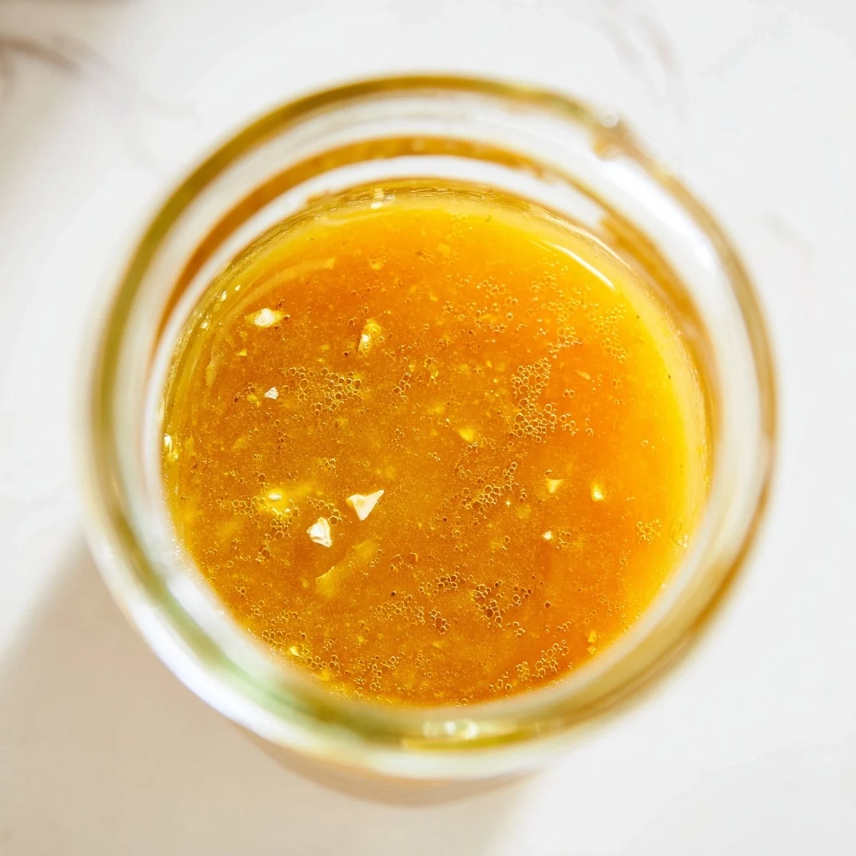 Bright citrus vinaigrette whisked to perfection with visible lemon zest and golden olive oil