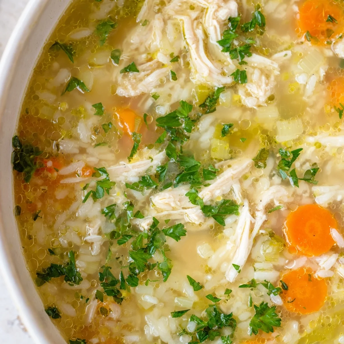Golden Crockpot Lemon Chicken Soup with tender shredded meat carrots and bright citrus broth