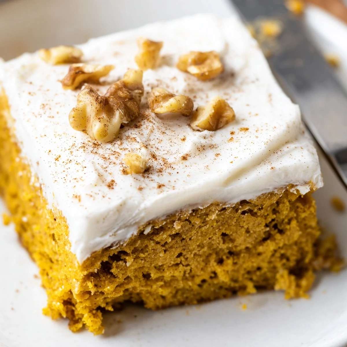 Moist pumpkin bars with cream cheese frosting sliced into golden spiced squares