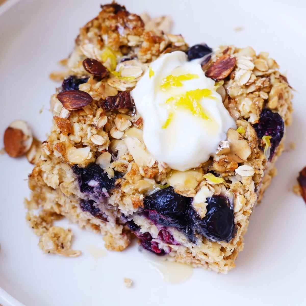 Warm High Protein Lemon Blueberry Breakfast Bake sliced and served with yogurt  