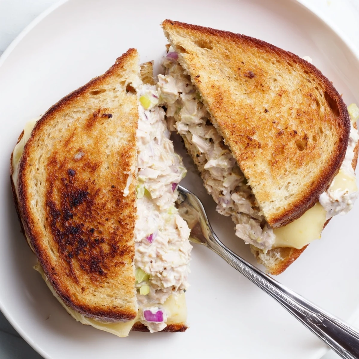Hot open-faced tuna melt sandwich bubbling with melted cheddar and savory tuna salad