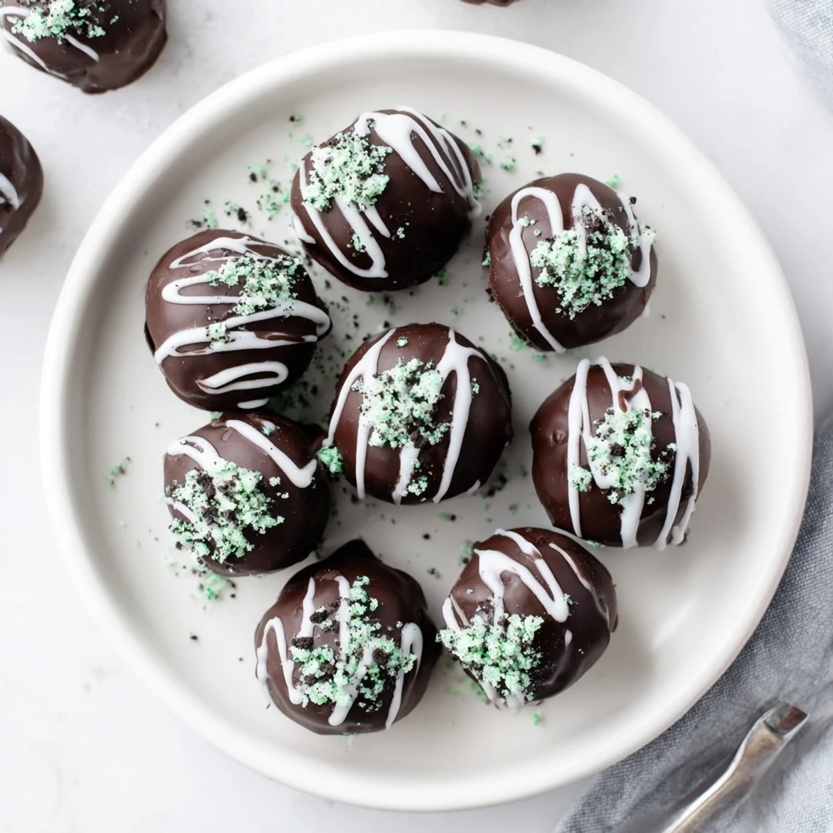 Creamy mint Oreo truffles dipped in melted chocolate and topped with cookie crumbs