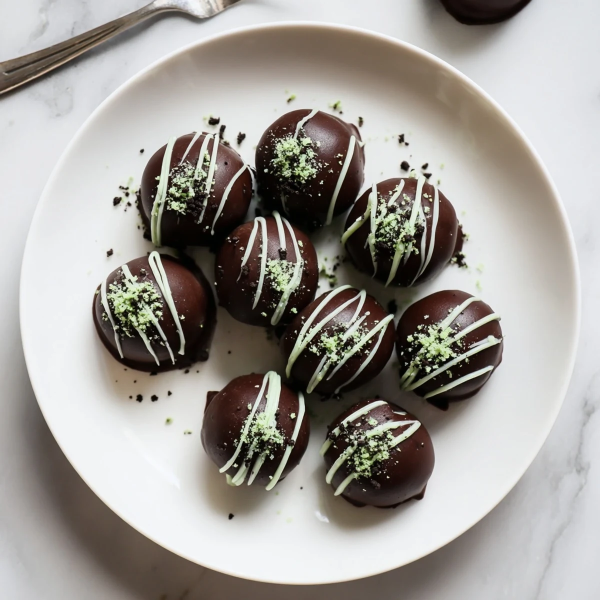 Bite-sized mint Oreo truffles coated in glossy dark chocolate with crushed cookie garnish