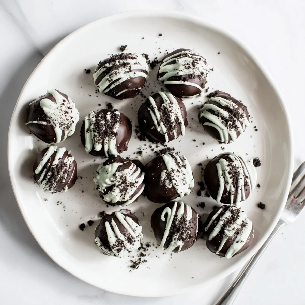 Homemade mint Oreo truffles featuring smooth dark chocolate coating and festive green garnish