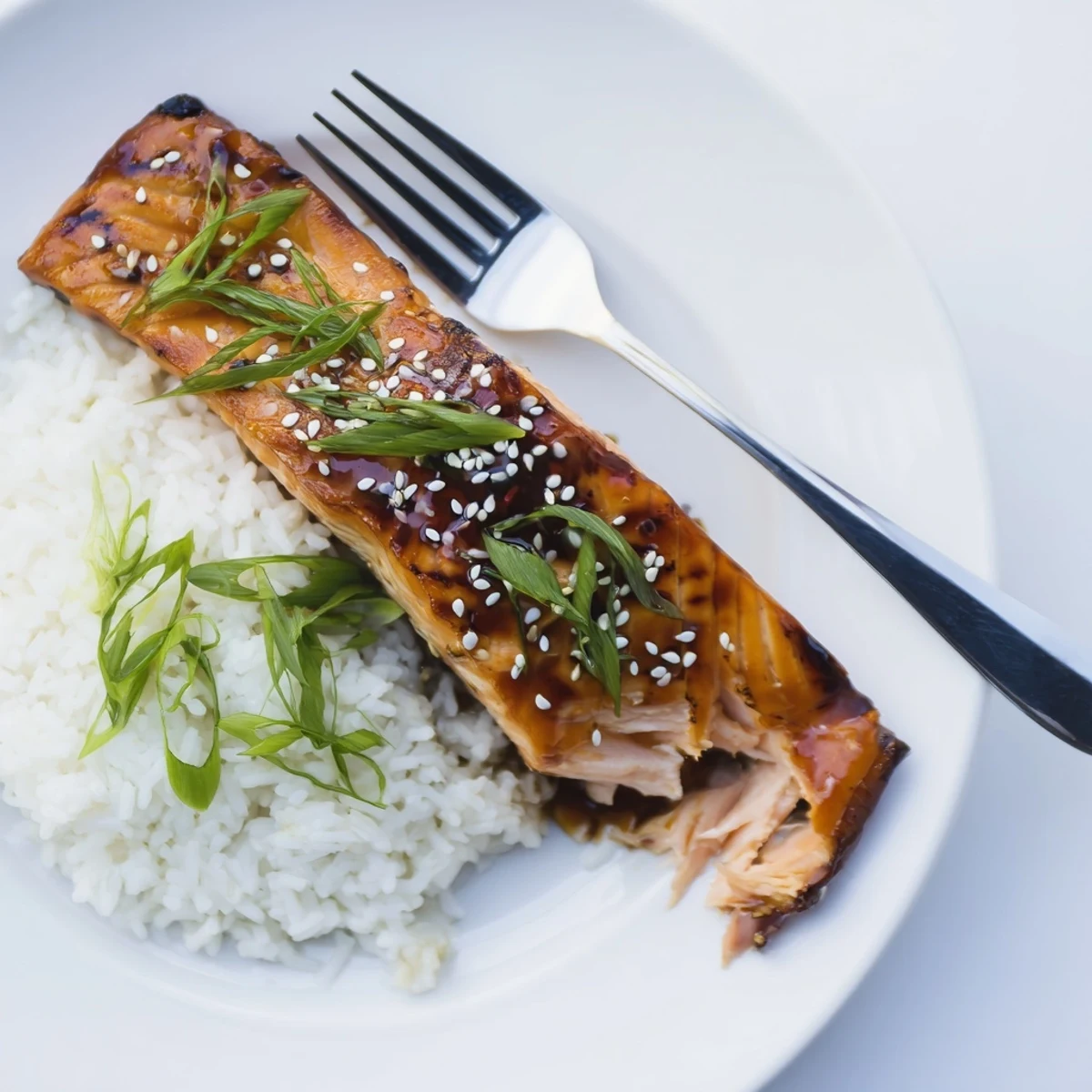 Baked Teriyaki Salmon glazed glossy and caramelized, resting on steamed rice.