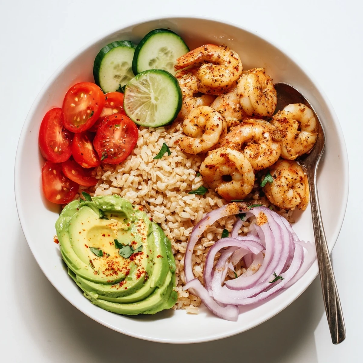 Steaming rice crowned with garlic shrimp, avocado, and lime in Garlic Shrimp Bowl