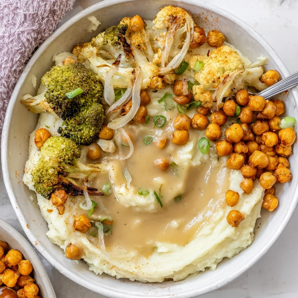 Creamy Vegan Mashed Potato Bowls topped with roasted veggies, crispy chickpeas, gravy.