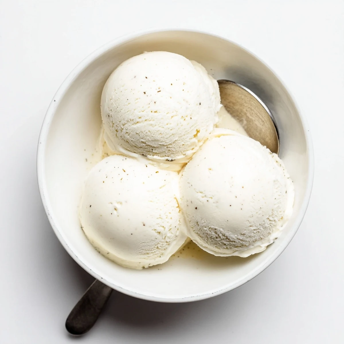 Rich vanilla ice cream swirl topped with chocolate sauce and whipped cream in sundae glass