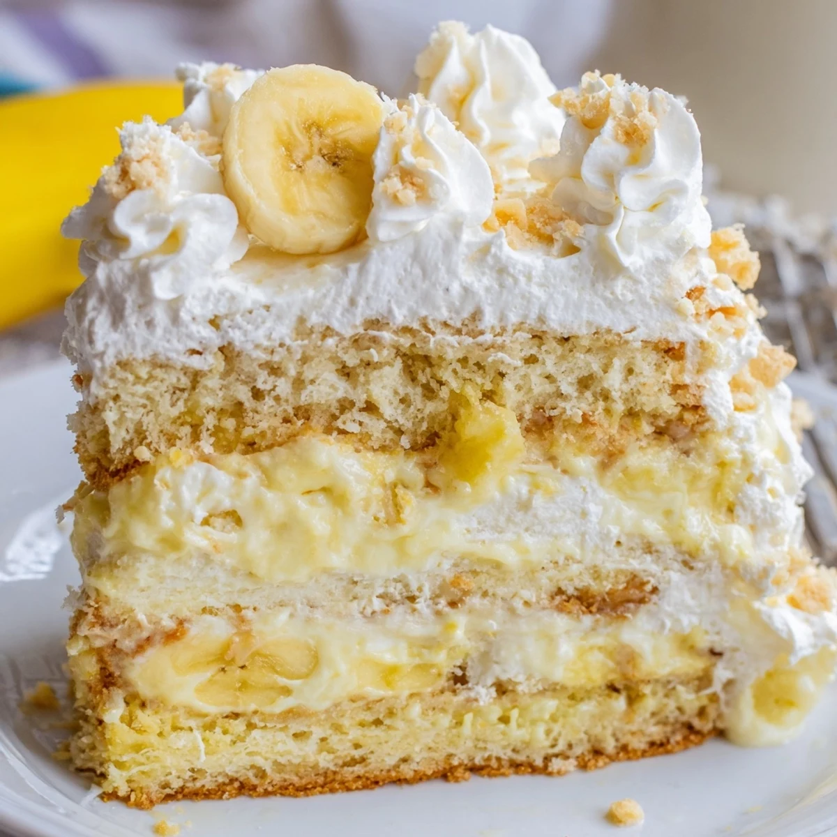 Moist banana pudding cake layered with creamy vanilla filling and crushed vanilla wafer cookies
