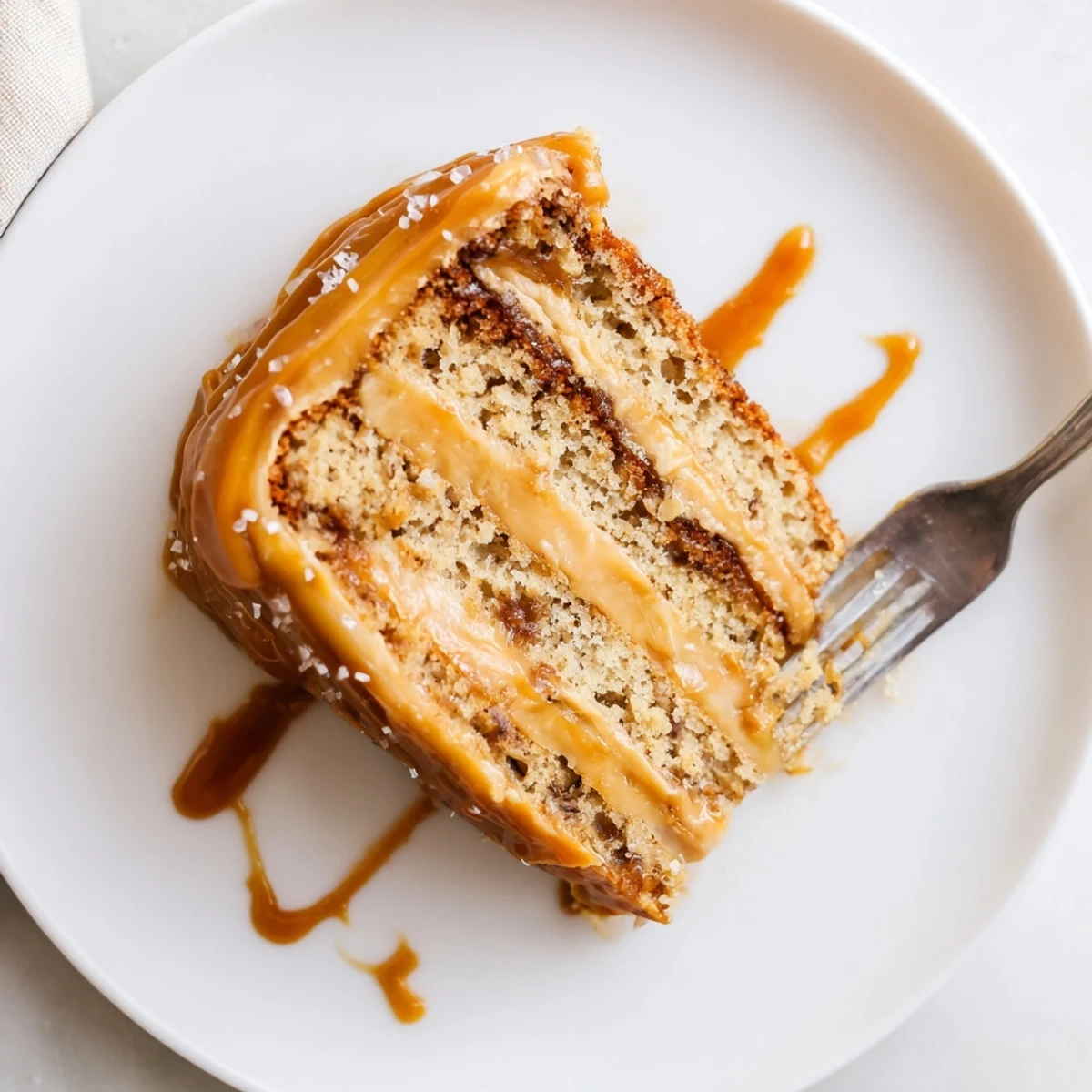 Moist salted caramel brown butter banana cake with golden caramel sauce dripping down the sides
