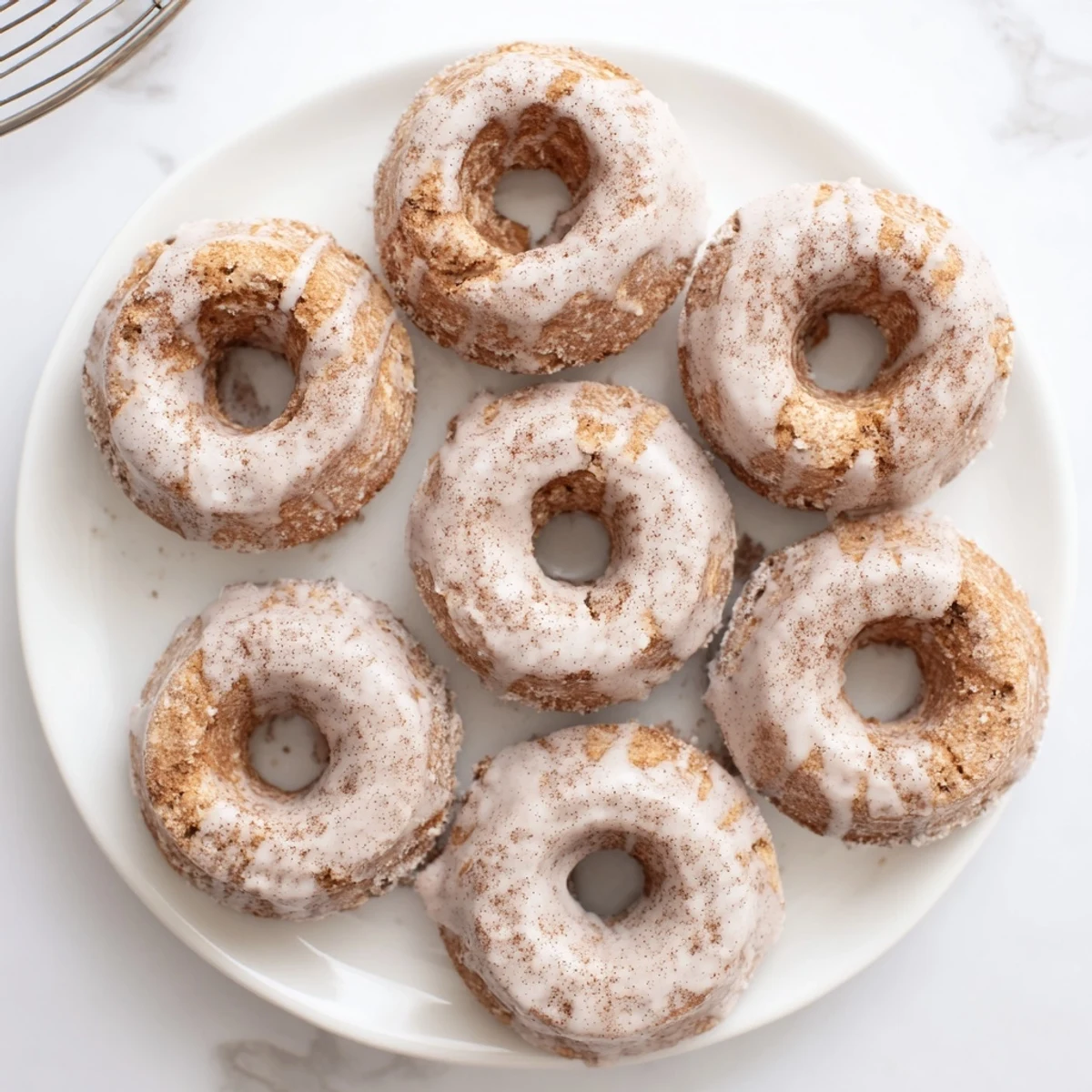 Moist banana bread donuts arranged on a decorative plate with ripe banana slices