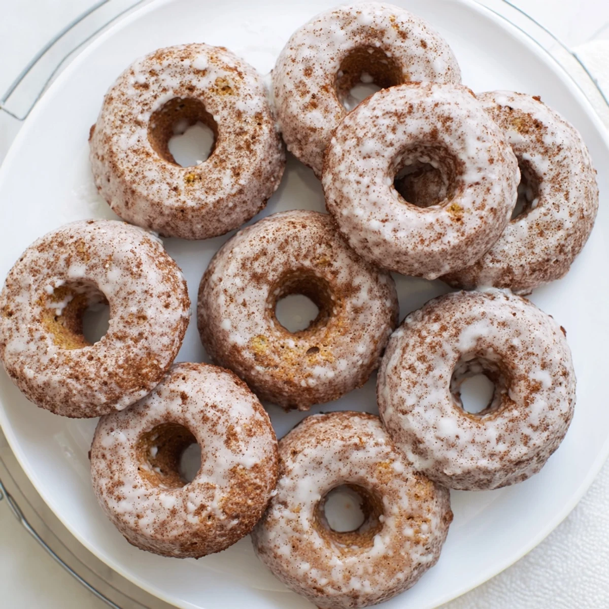 Soft baked banana bread donuts sprinkled with powdered sugar on a wooden cutting board