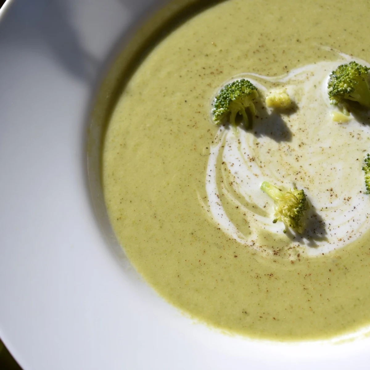 Creamy, warm bowl topped with florets and herb garnish, Broccoli Soup
