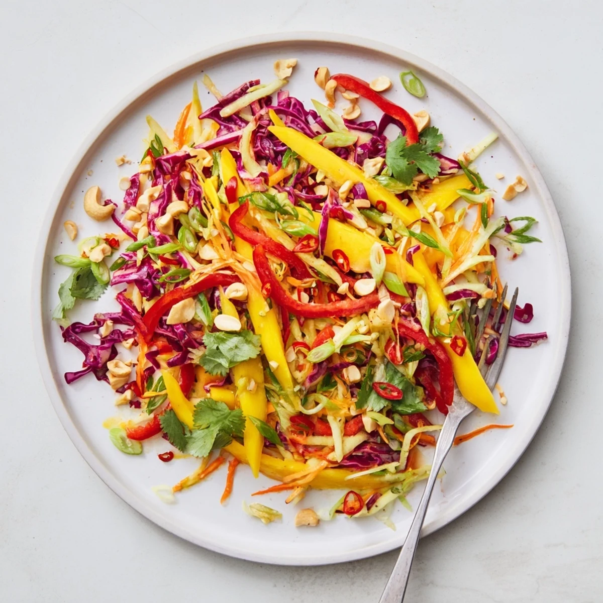 Colorful mango slaw featuring crunchy red cabbage, carrots, and fresh cilantro in a bowl