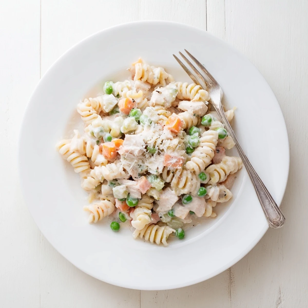 Creamy chicken pot pie pasta with tender vegetables and parmesan sauce served in a bowl