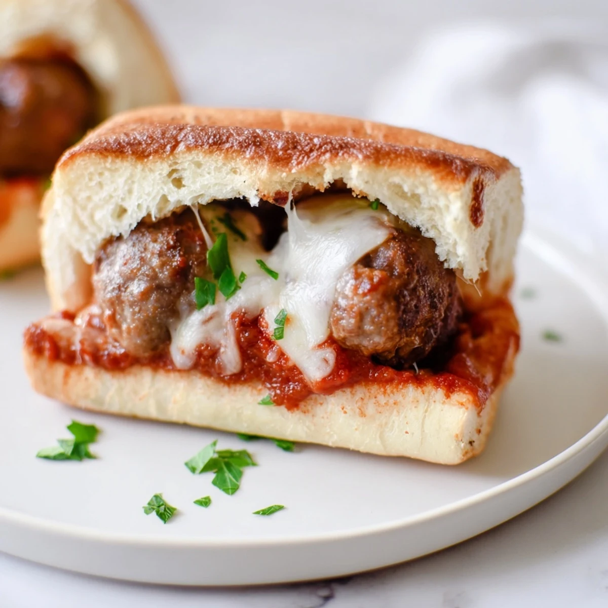 Golden brown meatballs nestled in toasted sub rolls topped with bubbling melted mozzarella cheese over rich marinara sauce