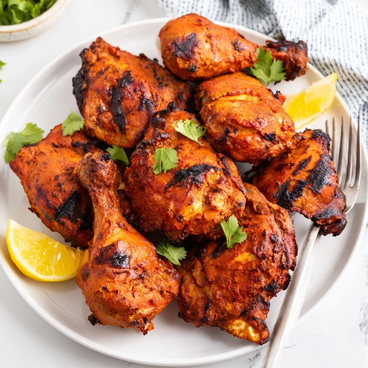 Succulent roasted tandoori chicken coated in aromatic spices and served with butter brushed on top alongside cilantro.