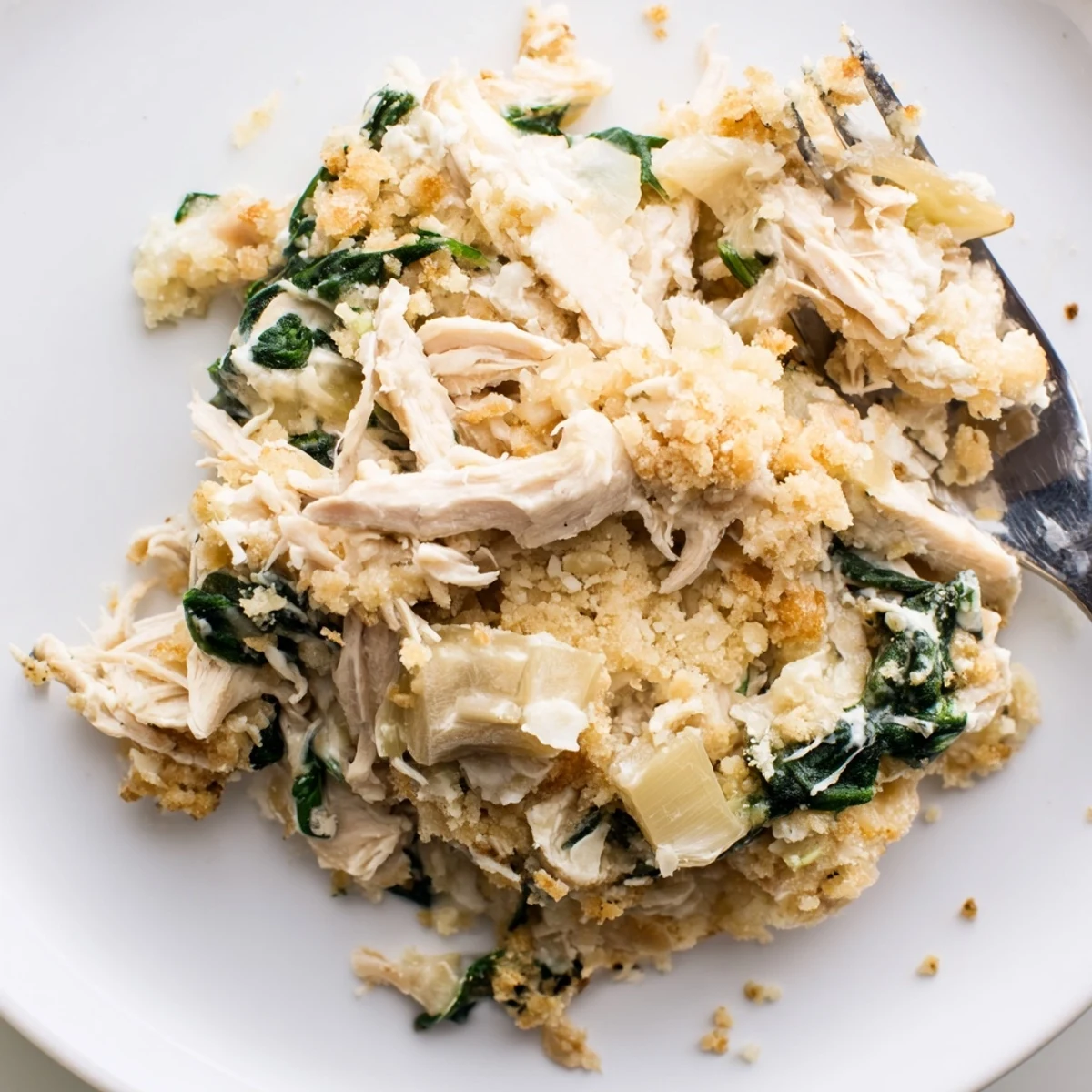 Oven-browned Spinach Artichoke Chicken Casserole served family-style alongside a crisp green salad