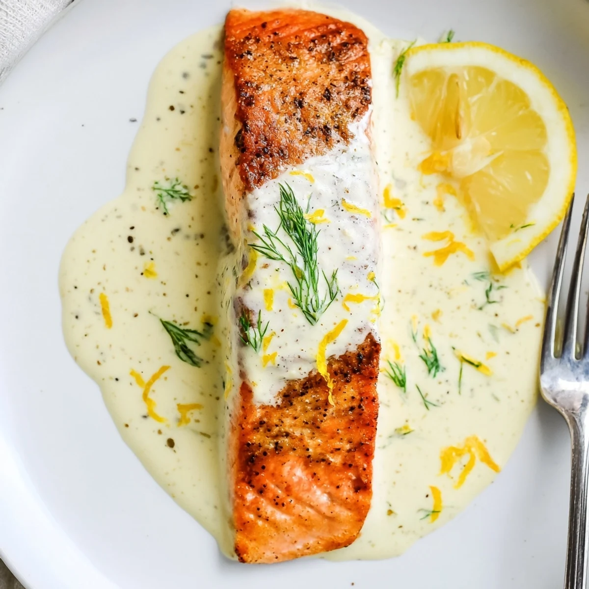 Tender Salmon With Lemon Cream Sauce nestled on rice, bright lemon zest