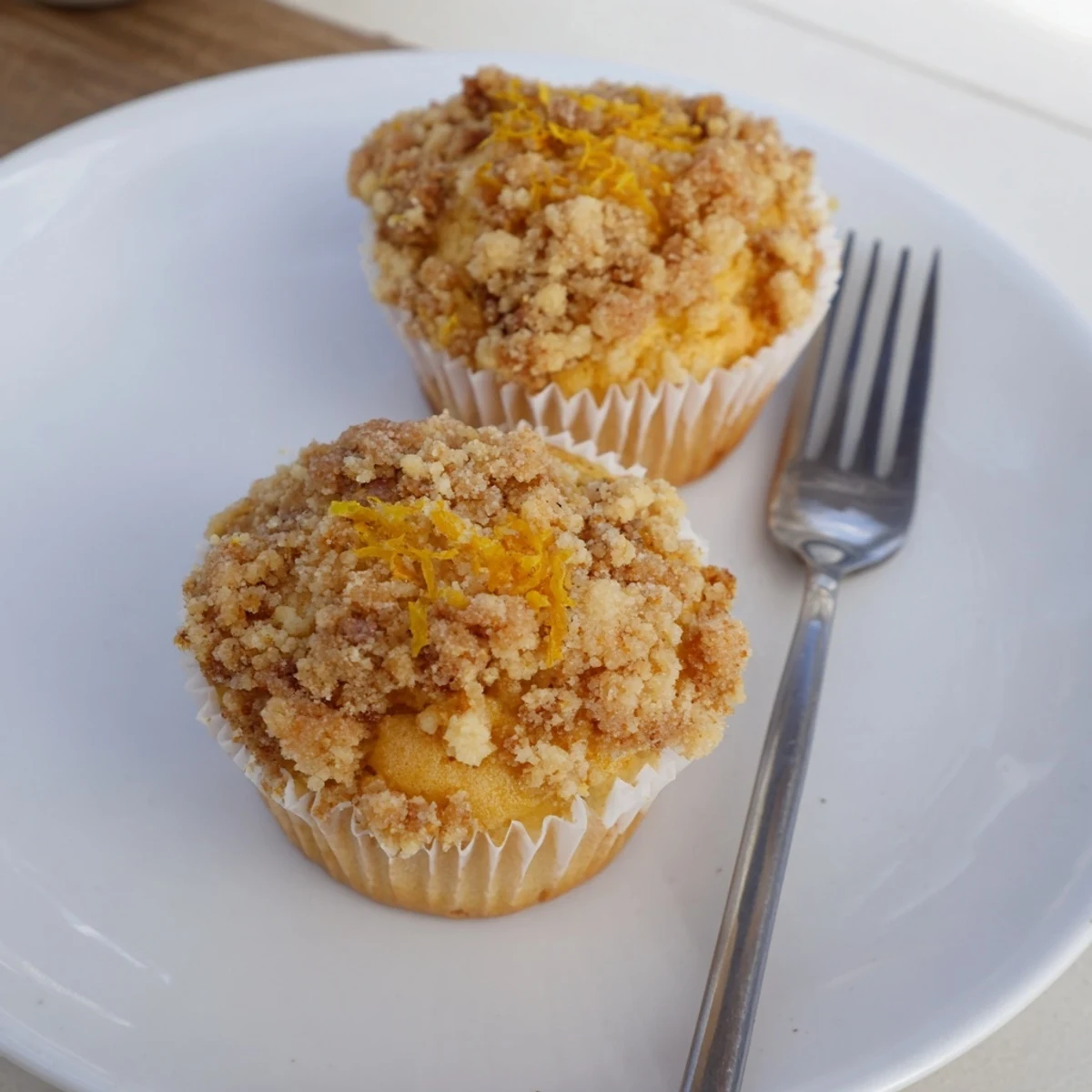 Golden lemon orange honey muffins with thyme crumble cooling on a rustic wire rack