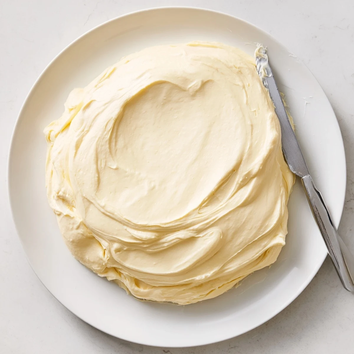 Fluffy Italian meringue buttercream piped into elegant swirls atop chocolate cupcakes