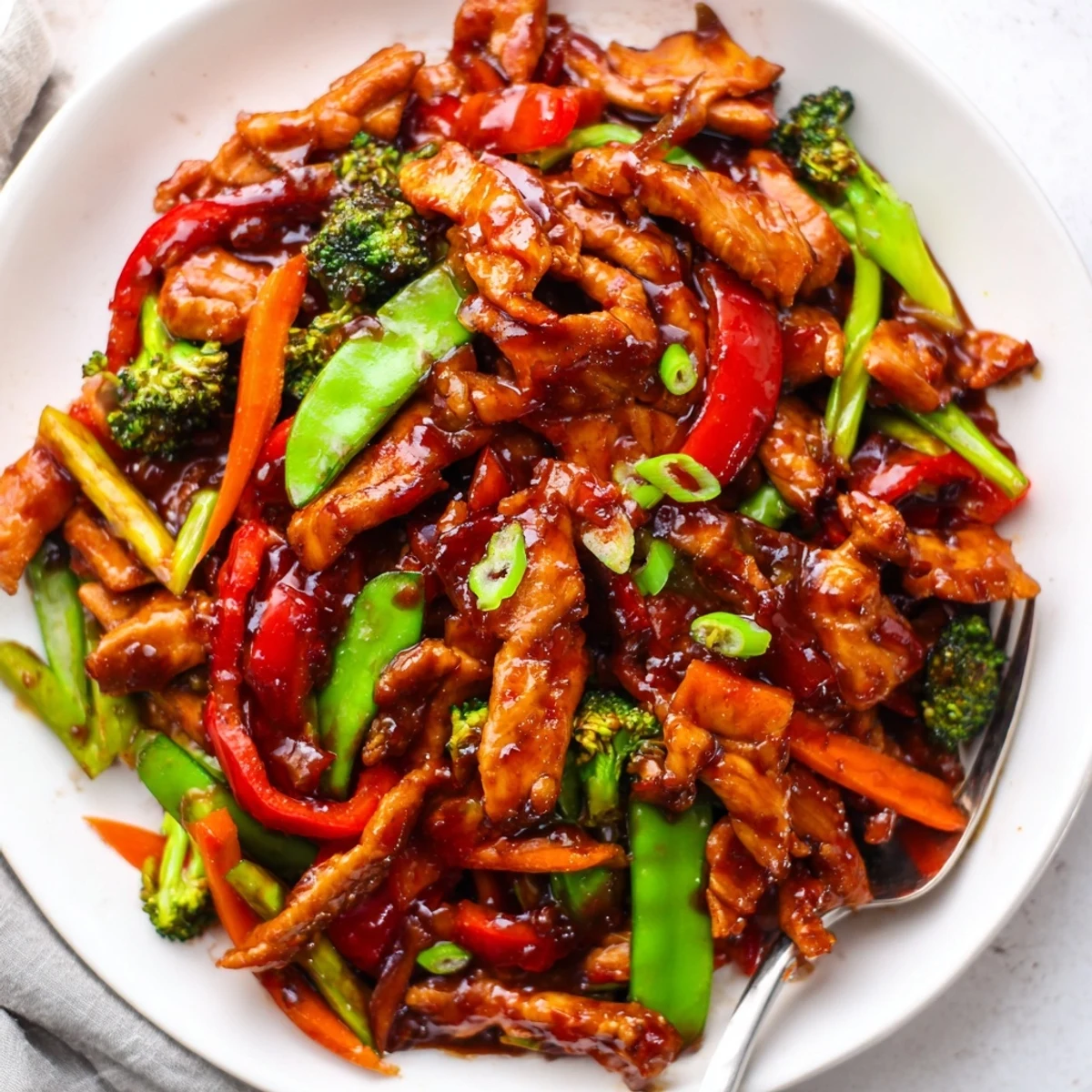 Tender sliced Hunan Chicken tossed with vibrant vegetables in a bold spicy wok sauce