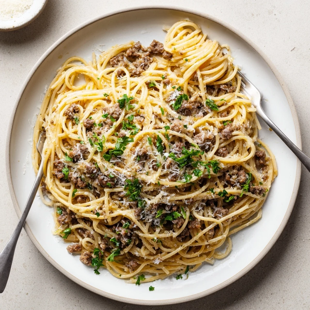 A steaming bowl of garlic butter pasta with ground beef coated in rich sauce